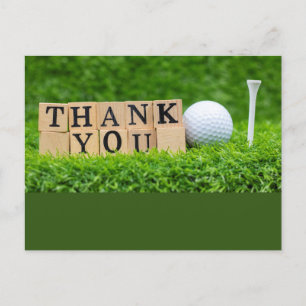 Golf ball with thank you word on green grass postcard