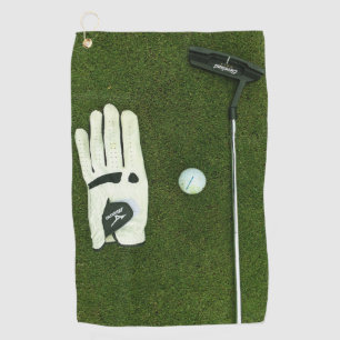 Golf glove and ball on grass Golf Towels