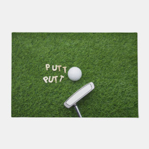 Golf put put with putter and golf ball on green doormat
