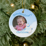 Grandaughter's 1st Christmas Snowman Round Photo Ceramic Tree Decoration<br><div class="desc">Your granddaughter will cherish her 1st christmas snowman ornament with her photo. This adorable showgirl is decked out in fuzzy blue hat, scarf and mittens as delicate snowflakes fall through the winter sky. Add photo to front and name and year to the back of the ornament using the template provided....</div>