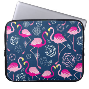 Graphic pattern of pink flamingos on a dark blue b laptop sleeve