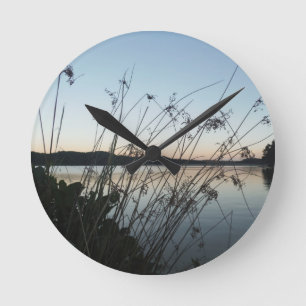 Grasses at lake Sunset Round Clock