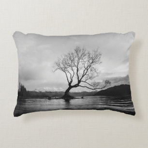 GRAYSCALE PHOTO OF BARE TREE ON CALM BODY OF WATER DECORATIVE CUSHION