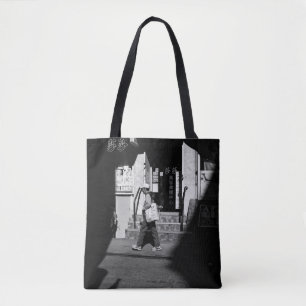 GRAYSCALE PHOTOGRAPHY OF PERSON WALKING BESIDE BUI TOTE BAG