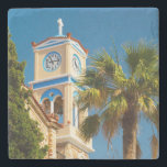 Greece - Orthodox Greek Church with Palm Tree Stone Coaster<br><div class="desc">A bright and summery photograph taken in Greece. An orthodox greek church and its quaint clock tower and steeple. Vibrant colours on this structure are sandstone coloured brick with accents in santorini blue. A giant leafy palm tree hovers above. The sky is clear blue and shows off the stark white...</div>