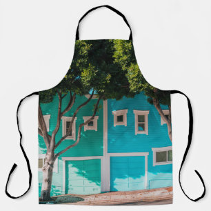 Green and blue houses beside trees on sidewalk apron