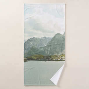 GREEN AND BROWN MOUNTAINS NEAR BODY OF WATER UNDER BATH TOWEL