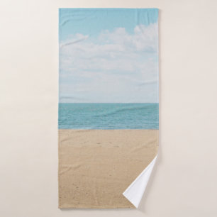 Green artificial palm tree on seashore bath towel