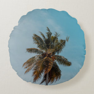 Green coconut tree under blue sky round cushion