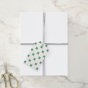 Green cross stitches on white gift tags