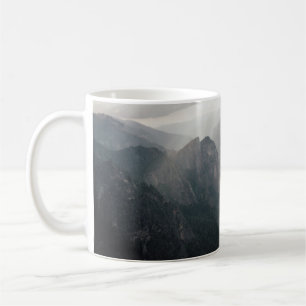 GREEN GRASS FIELD AND MOUNTAINS DURING DAYTIME COFFEE MUG