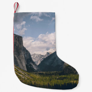 GREEN GRASS FIELD NEAR ROCKY MOUNTAIN UNDER WHITE SMALL CHRISTMAS STOCKING