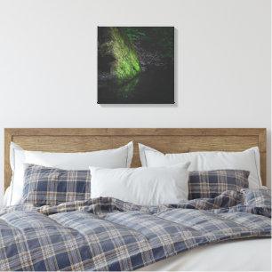 Green mossy rock with reflection in water canvas print