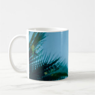 Green palm tree under blue sky in the morning coffee mug