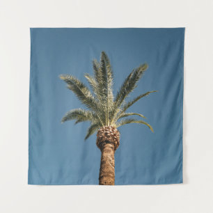 Green palm tree under blue sky in the morning tapestry