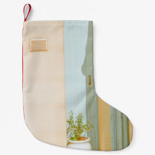GREEN PLANT WITH CERAMIC VASE BESIDE WHITE WOODEN  SMALL CHRISTMAS STOCKING