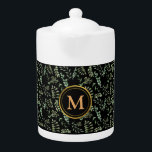 greenery botanical leaves pattern black teapot<br><div class="desc">The teapot showcases a captivating design featuring lush green botanical leaves intricately intertwined on a sleek black background, creating a harmonious and refreshing ambiance. To add a touch of personalisation, we've adorned the teapot with a luxurious gold monogram, elegantly displaying your initials or name. Crafted with care, this teapot is...</div>