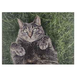 grey cat lying in the grass digital art cutting board