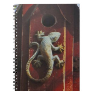grey lizard on worn wood notebook