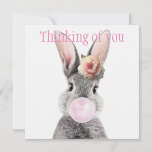 Grey rabbit blowing bubble gum with anemone flower