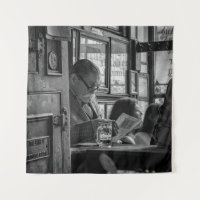 GREYSCALE PHOTO OF MAN SITTING WHILE READING NEWSP