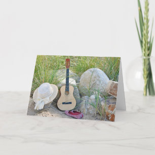 guitar with hat and shoes on beach card