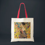 Gustav Klimt Lady With Fan Art Nouveau Painting Tote Bag<br><div class="desc">Gustav Klimt Lady With Fan Art Nouveau Painting This half portrait of a beautiful woman shows a yellow background with asiatic ornaments, colourful birds and lotus flowers. The lady wears a dress in the style of a kimono imprinted with motives of a Chinese dragon dress. Beautiful artistic romantic decorative fine...</div>