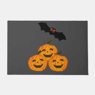 Halloween funny. Pumpkins and a flying bat. Doormat