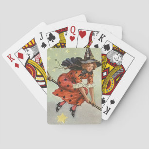Halloween witch on a flying broom playing cards