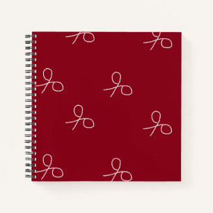 Hand drawn scissors on maroon red notebook