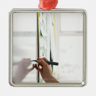 hand holding marker pen on school whiteboard metal tree decoration