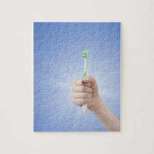 Hand holding tooth brush jigsaw puzzle