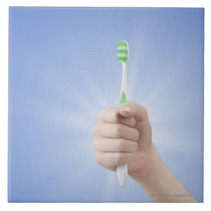 Hand holding tooth brush tile