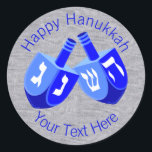 Hanukkah Dreidels In Blue Cheerful Kids Design Classic Round Sticker<br><div class="desc">Use these fun round Hanukkah stickers as party favours, to dress up a gift package, to seal envelopes or anything else your DIY self can imagine. The double Dreidel design in white and bright blues is my original artwork so these Chanukah stickers are one-of-a-kind. Set on a faux bling silver...</div>
