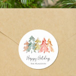 Happy Holidays Pine Tree Watercolor Christmas Classic Round Sticker<br><div class="desc">Simple and elegant stickers for your Christmas gifts and correspondence featuring a watercolor abstract of pine trees in muted sage green,  red,  gold and orange,  "Happy Holidays" in a stylish script and your name in modern typography.</div>
