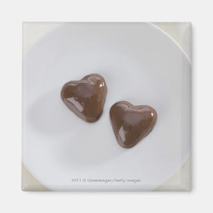 Heart shaped chocolate candies on a plate magnet