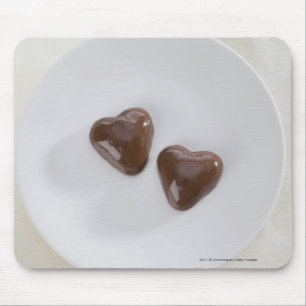 Heart shaped chocolate candies on a plate mouse mat