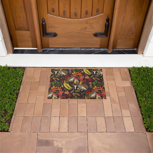 Hedgehogs and autumn forest flora on black doormat (Outdoor)