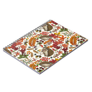 Hedgehogs and autumn forest flora on ivory notebook