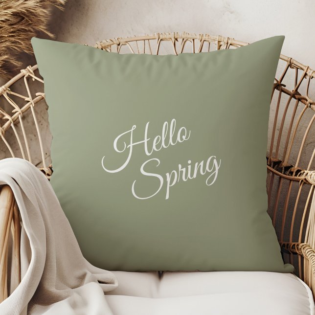 Hello Spring Sage Green Throw Pillow (Hello Spring Sage Green Throw Pillow in a  boho neutral rattan armchair.)