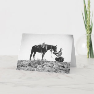 Horse eating from a cowboy's hat card