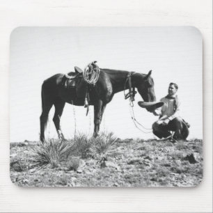 Horse eating from a cowboy's hat. mouse mat