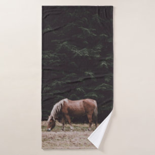 HORSE GRAZING IN THE SHADE OF CONIFERS BATH TOWEL