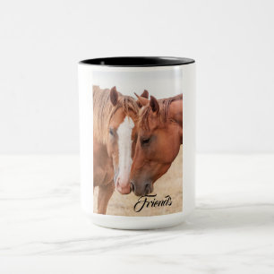 Horses nuzzling in a pasture mug
