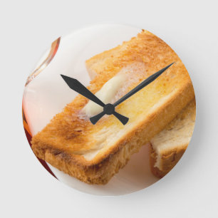 Hot toast with butter on a white plate close-up round clock
