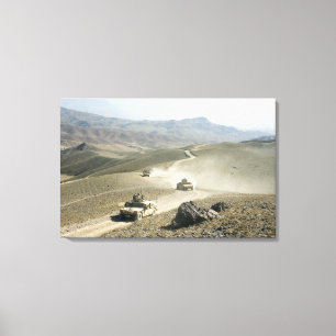 Humvees traverse rugged mountain roads canvas print