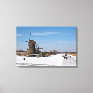 Ice skating along the windmills in winter canvas print
