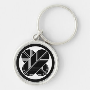 Intersecting hawk feathers with foot in circle key ring