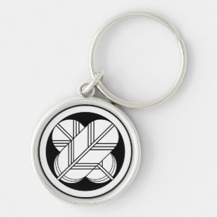 Intersecting hawk feathers with foot in circle key ring