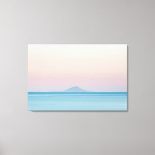 Island silhouette on horizon at sunset canvas print